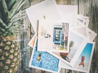 Assorted Photo Beside Pineapple on Top of Brown Surface