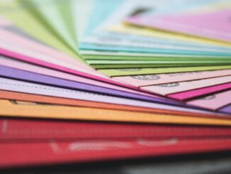 a close up of many different colored papers