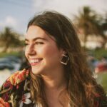 smiling woman wearing black and orange floral top