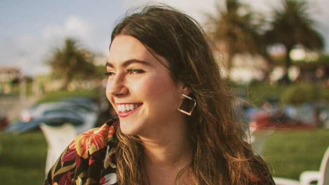 smiling woman wearing black and orange floral top